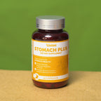 Supplement bottle labeled 'Stomach Plus' on a wooden surface with a green background
