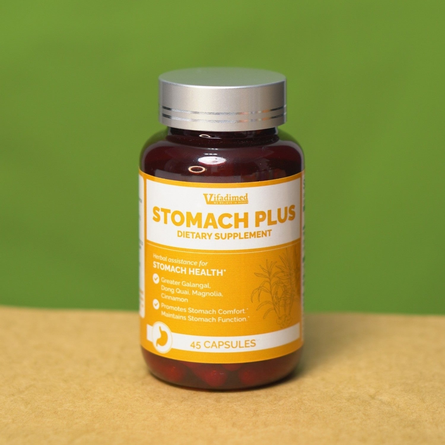 Supplement bottle labeled 'Stomach Plus' on a wooden surface with a green background