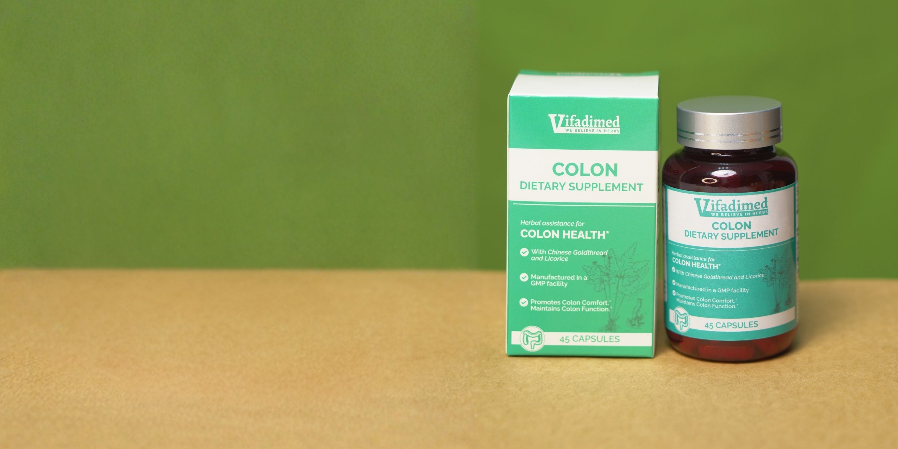 Vifadimed Colon Health dietary supplement bottle and box on a wooden surface with a green background